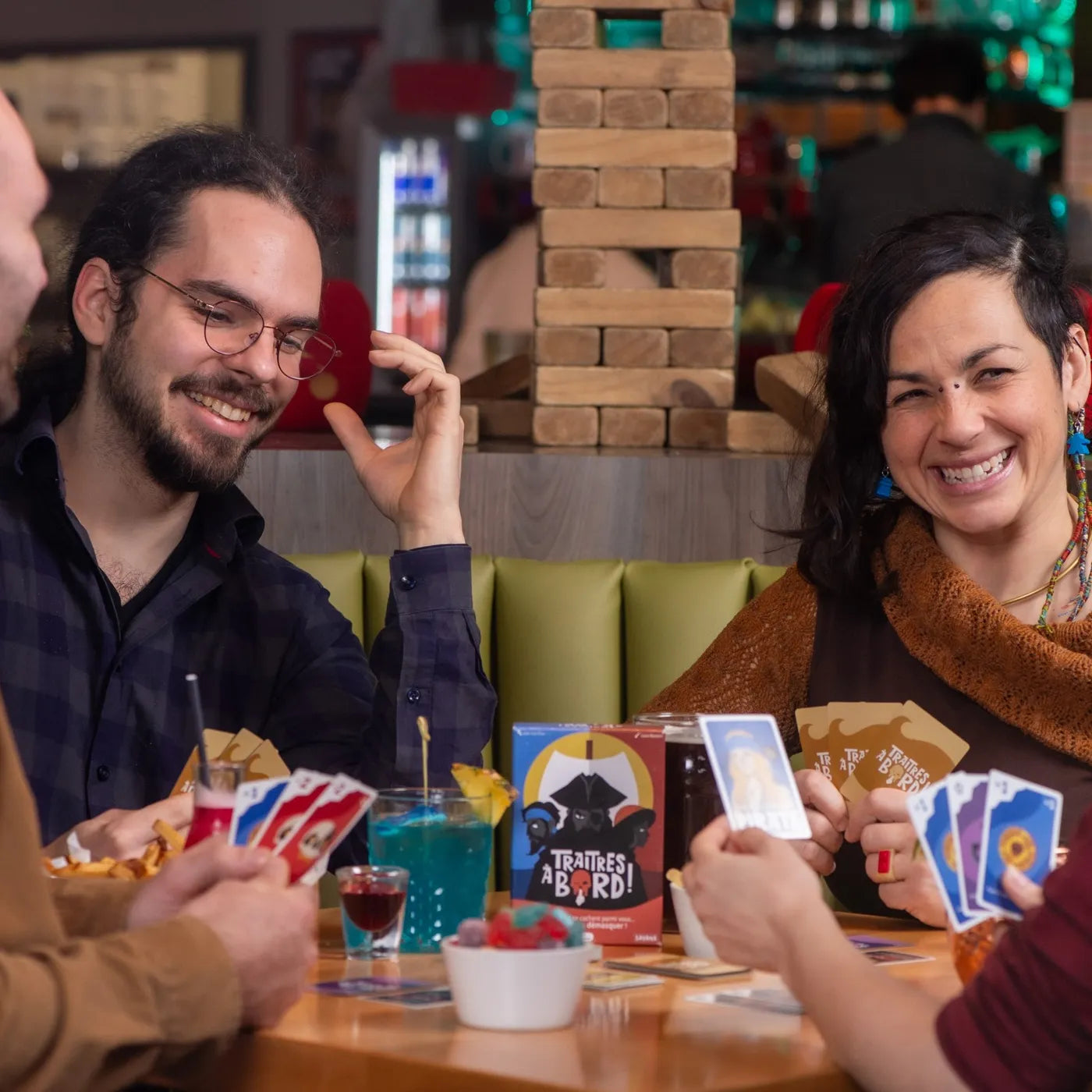Two friends laughing, Traitors Aboard cards in hand
